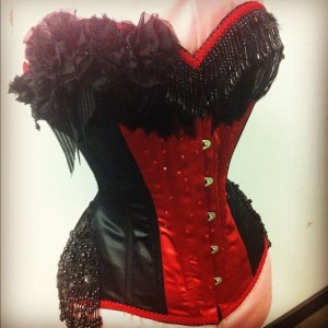 A stunningly embellished classic red and black ensemble by Sweet Carousel Corsetry.