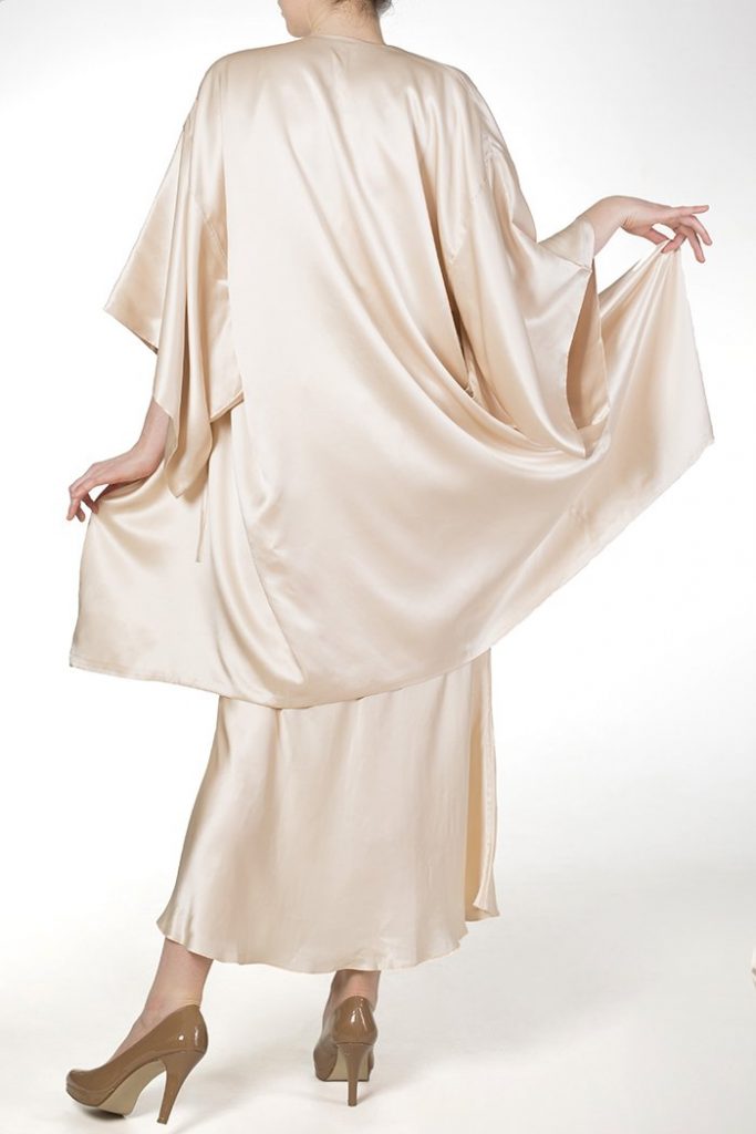 Model faces away from camera wearing ivory robe and long nightgown made of real silk