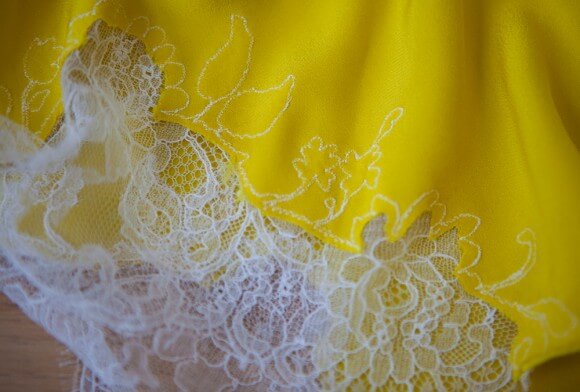 Interior view of machine-stitched lace appliqué on a Carine Gilson garment. Photography by K Laskowska