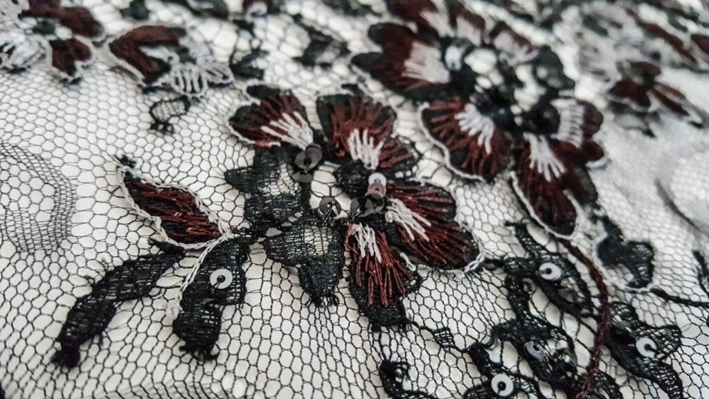 A rebrodée lace up close. The base lace is made of plain black twisted threads, and is later embellished with sewn on colourful threads and beads. Photo by Karolina Laskowska