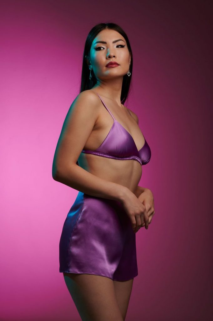 Model wears purple triangle bralette and tap shorts made of real silk by Angela Friedman