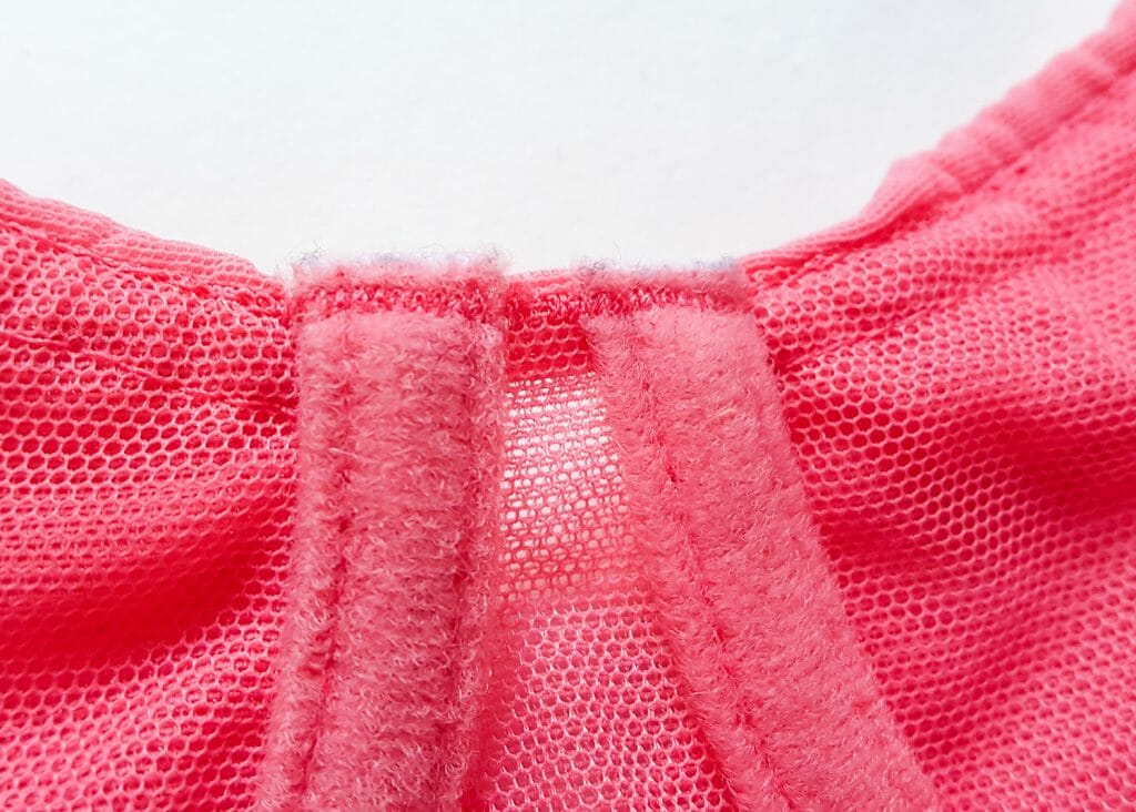 Underwire channels are typically sealed with a bartack stitch. This has the appearance of a tight zigzag and is very unlikely to fray or break. It's one of the most secure stitches, but is also difficult and time consuming to apply. Photo by K Laskowska