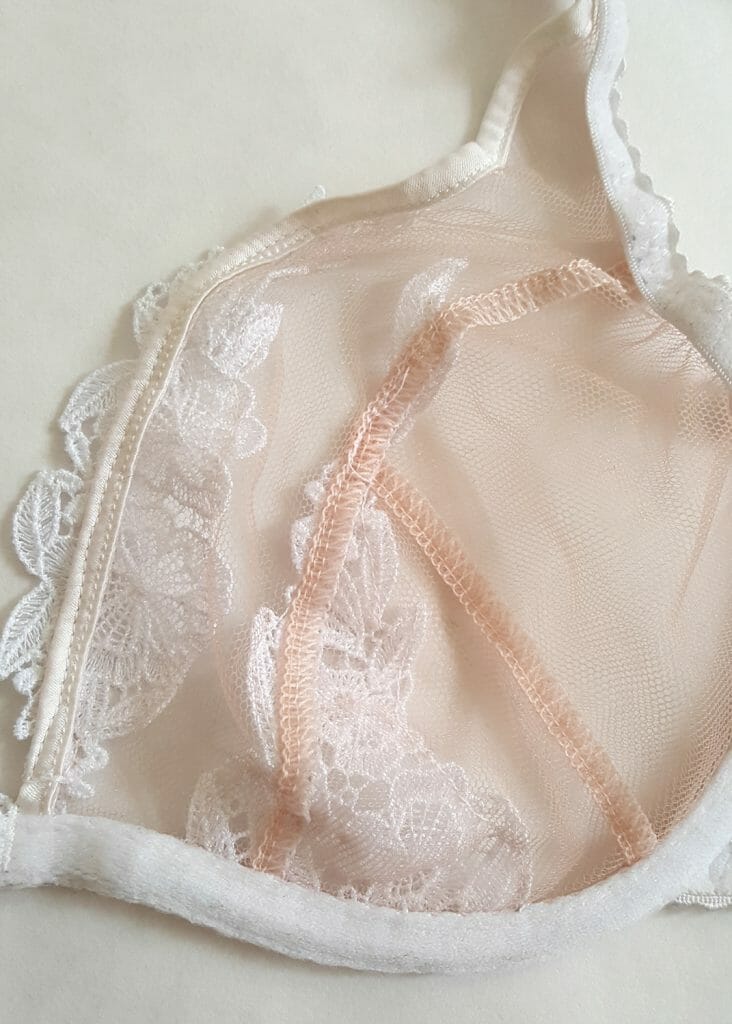 The bust seams on this Fleur of England bra are sewn with an overlock stitch. The neck edge of the bra is finished with a silk binding, the wire casing attached with a twin needle lockstitch, and the underarm elastic attached with a 3-point zigzag. Photo by K Laskowska