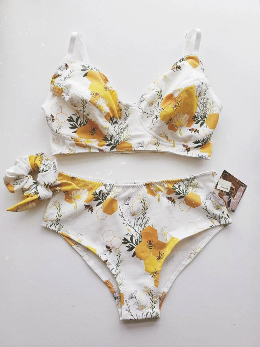 Lingerie set by EmMeMa. Wireless bra and brief panty with with yellow flower, honeycomb, and bee motif on white background.