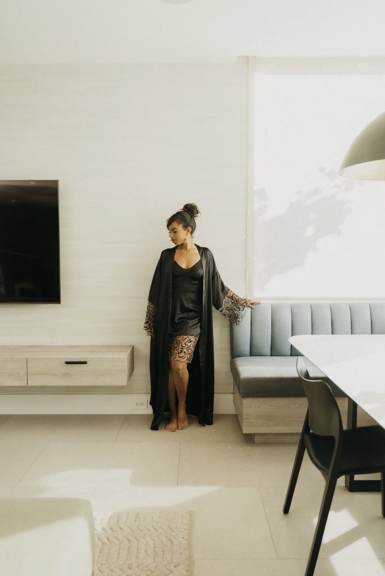 Hadal Lingerie love language robe and dress. Both items in black silk. Dress has deep hem of black arabic calligraphy on sheer tulle. Robe has deep sleeves of arabic calligraphy on sheer tulle.