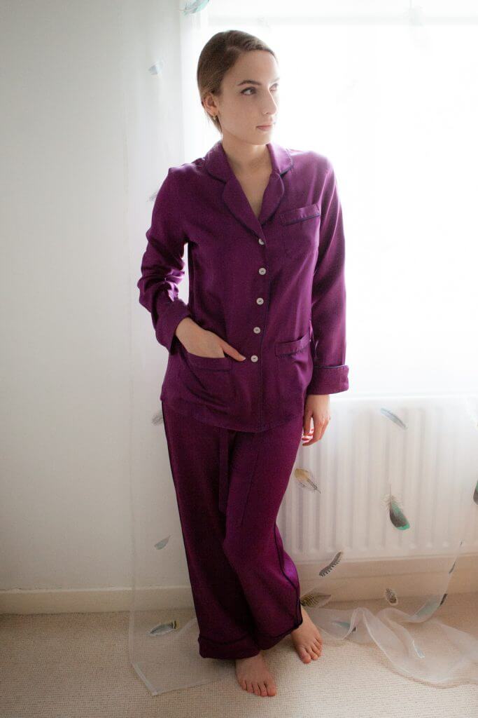 Model in silk lingerie pyjama set. Olivia Von Halle silk, purple buttoned pyjama top and pants.