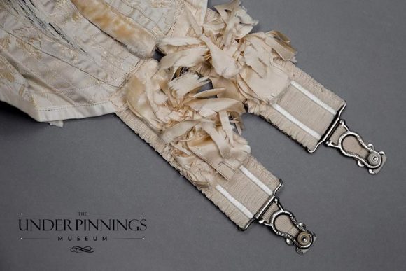 Silk rosette details on ruffled elastic suspenders, from an Edwardian corset in The Underpinnings Museum collection. Photo by Tigz Rice Studios