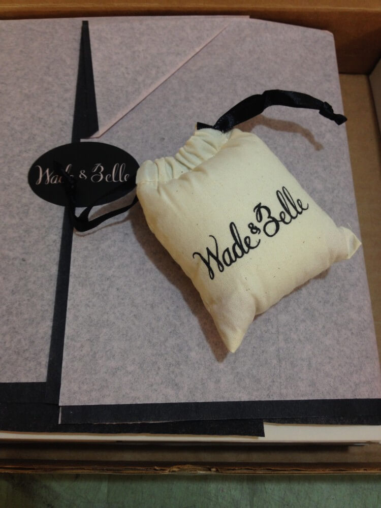 Wade & Belle "Not Too Tights" packaging: tissue paper wrapped tights, branded sticker, branded perfume sachet, fitted perfectly into a compact shipping box.
