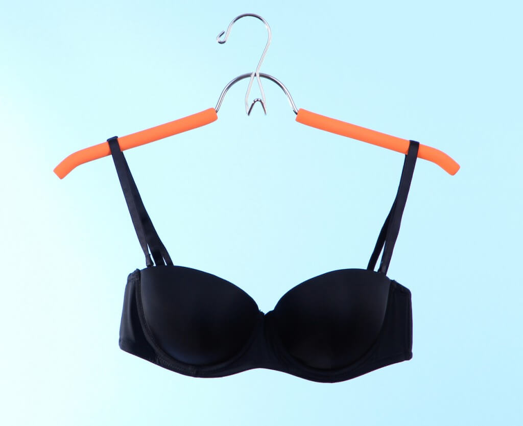 elegant bra on hanger on blue background