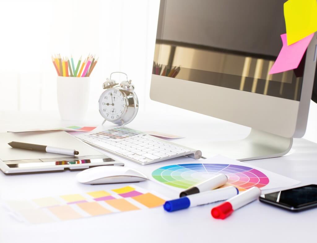 Modern office workplace with digital tablet, notepad, colorful pencils, glasses, in morning