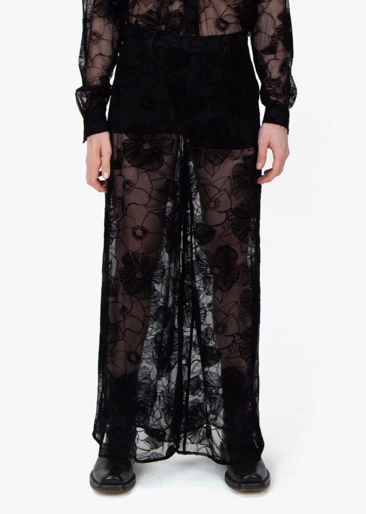 Lower front profile, Fomme Gender Neutral Black Lace Pajamas with flower-patterned flocking. Wide leg pants with hidden, side zip closure.