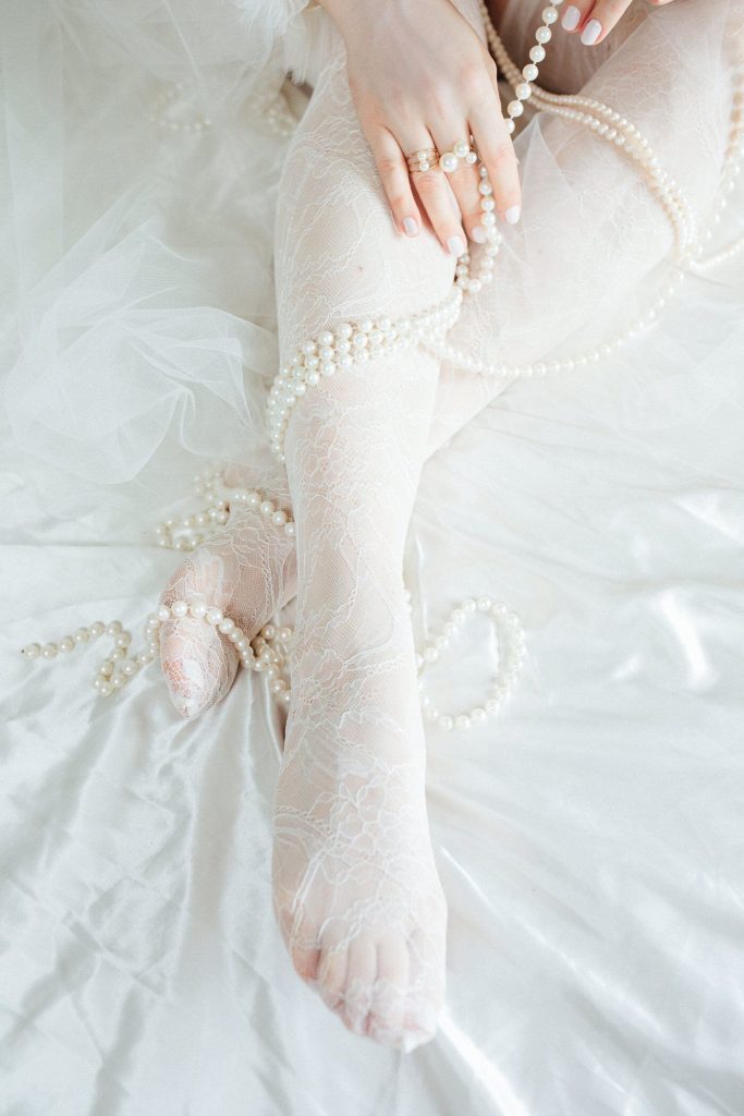 Close up of Alycya Ivory lace stockings with embroidered flower detailing.