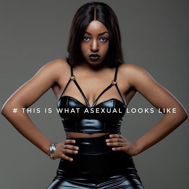 Yasmin Benoit wearing a black latex look bra and high-waist pants in an ad saying, "This is what asexual looks like"