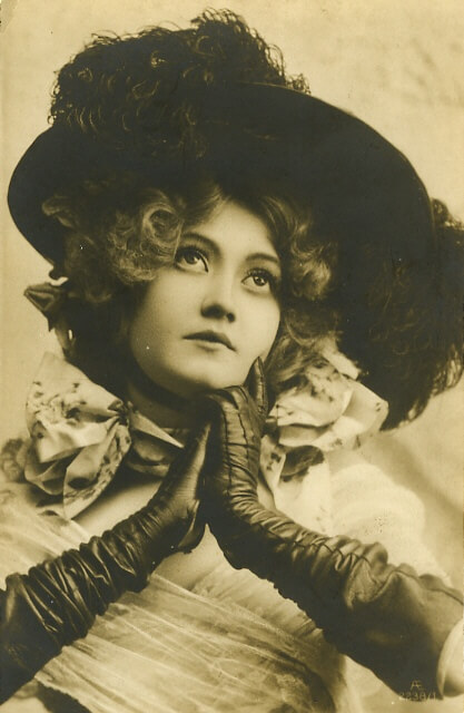 Vintage portrait of woman in hat and leather gloves.